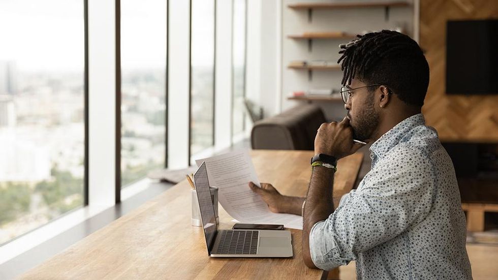 Man on laptop edits his resume during a job search