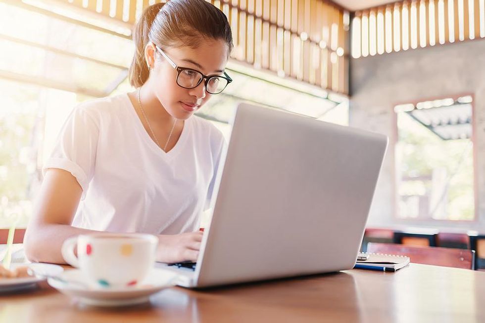 Woman on laptop editing her resume before applying for a job