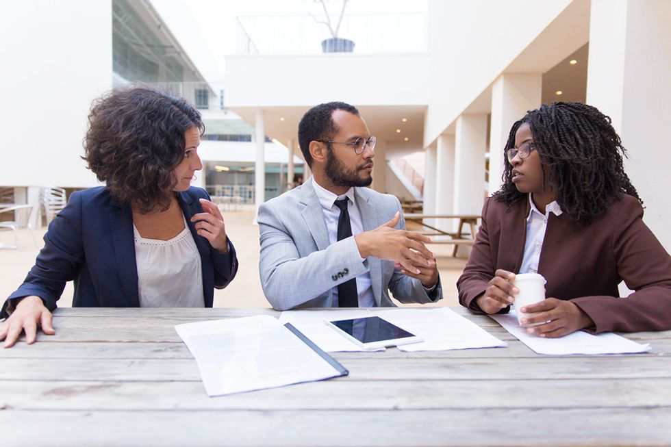 Professionals listen to a friend talk to help him through a career challenge