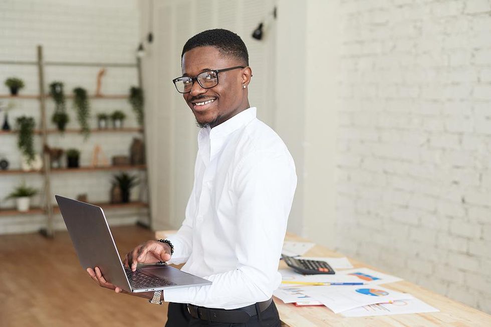 Man holding laptop happy at work after changing careers