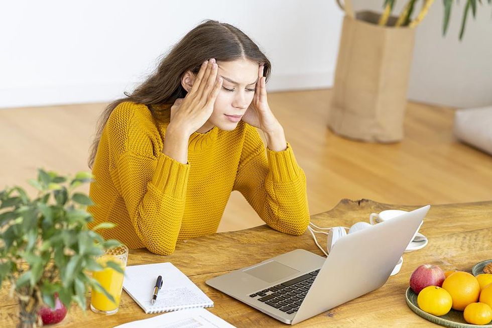 Professional on laptop shows signs of stress and frustration on a Monday morning