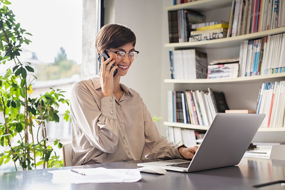 Woman on laptop and phone stays connected as she relaunches her career