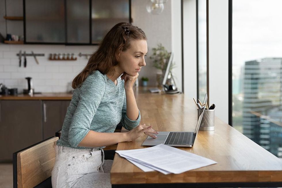 Job seeker on laptop updates her resume