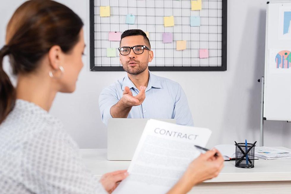 Woman checks her employment contract with her boss