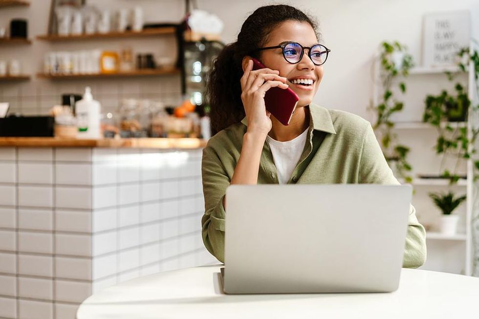 Woman on phone and laptop asks for a LinkedIn recommendation